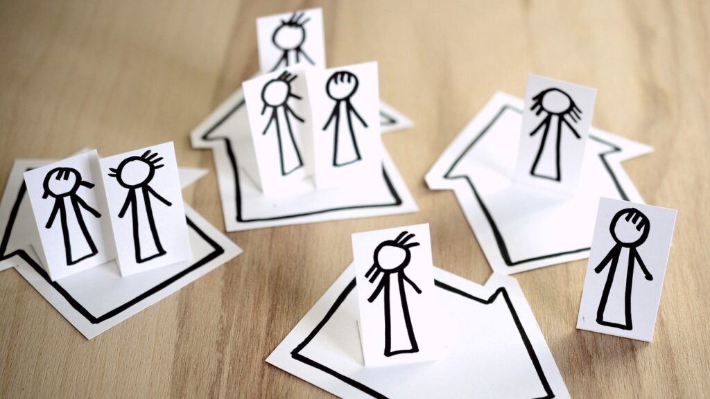 Stick figure drawings of people in groups of ones, twos and threes, standing on top of arrows pointing in different directions.