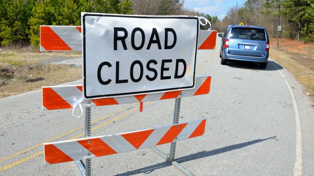 A 'road closed' sign blocks access to a road.